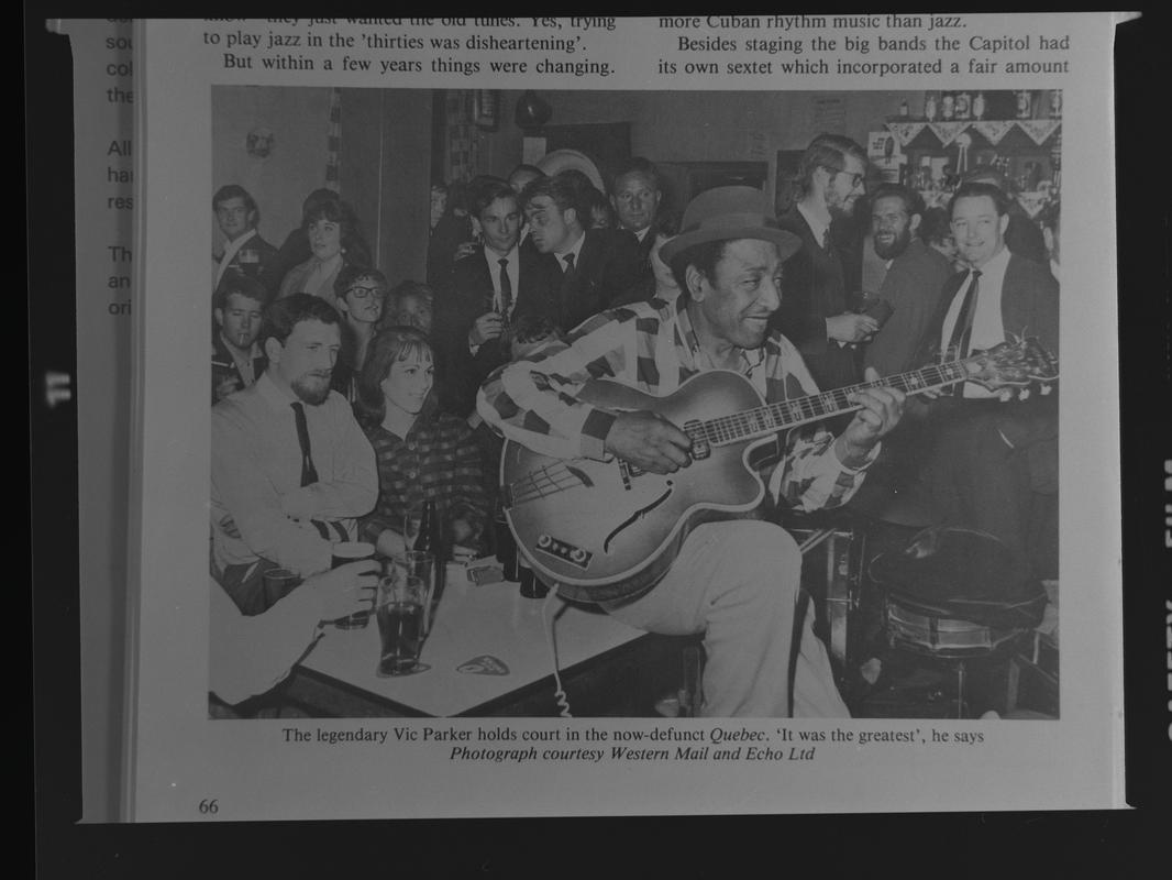 Copy of photograph - "The legendary Vic Parker holds court in the now-defunct Quebec". The Quebec was situated at the rear of the Custom House pub on Bute Street.