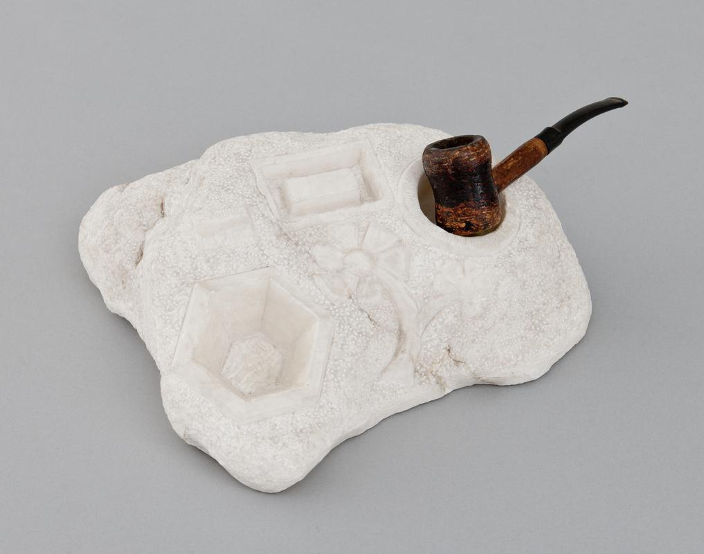 Carved block of  alabaster with a smoking pipe. Made by German prisoner of war at Penarth.