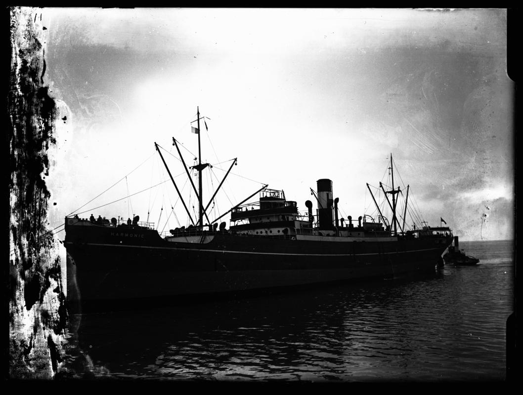 Port broadside view of S.S. HARMONIC and tug, c.1936.