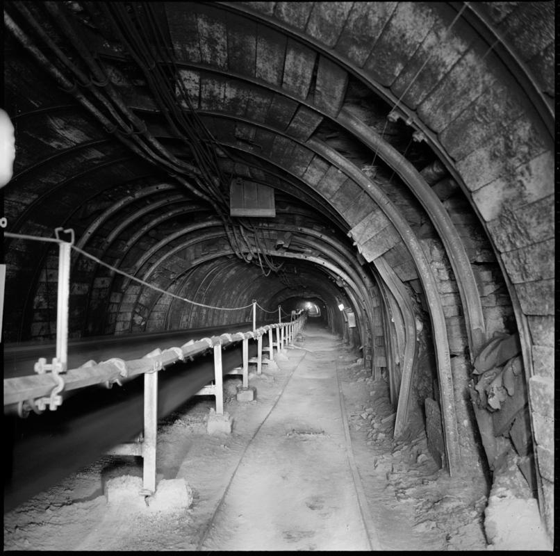 Black and white film negative showing a roadway and conveyor belt, Coegnant Colliery 1978-1979.  'Coegnant 1978-9' is transcribed from original negative bag.