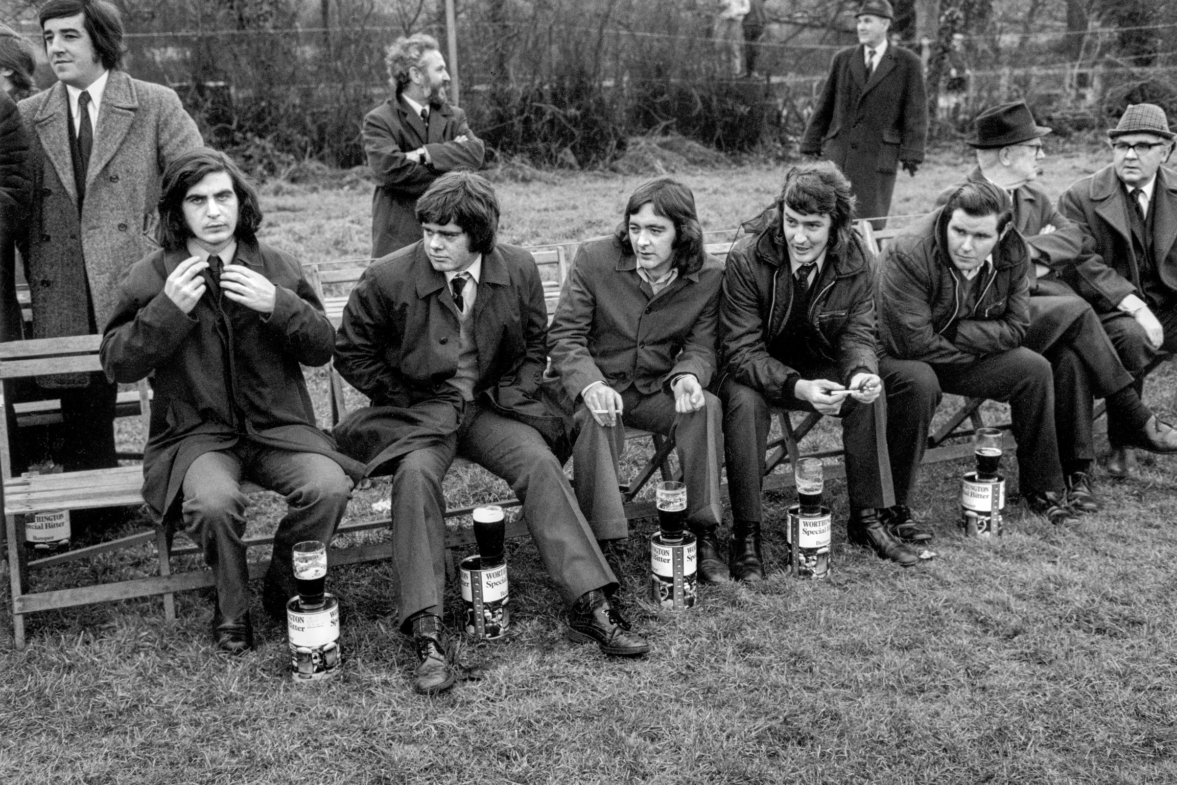 Spectators at an Old Boys rugby match. Beer seems an essential part of the whole macho experience. Rhondda Valley, Wales