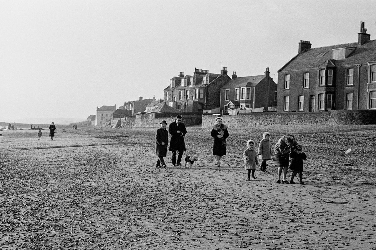 GB. SCOTLAND. A family walk on the beach at Largo in East Scotland, the birthplace of Alexander Selkirk;  who was the sailor who was the character that Robinson Cruscoe was written about by Daniel Defoe. 1967.