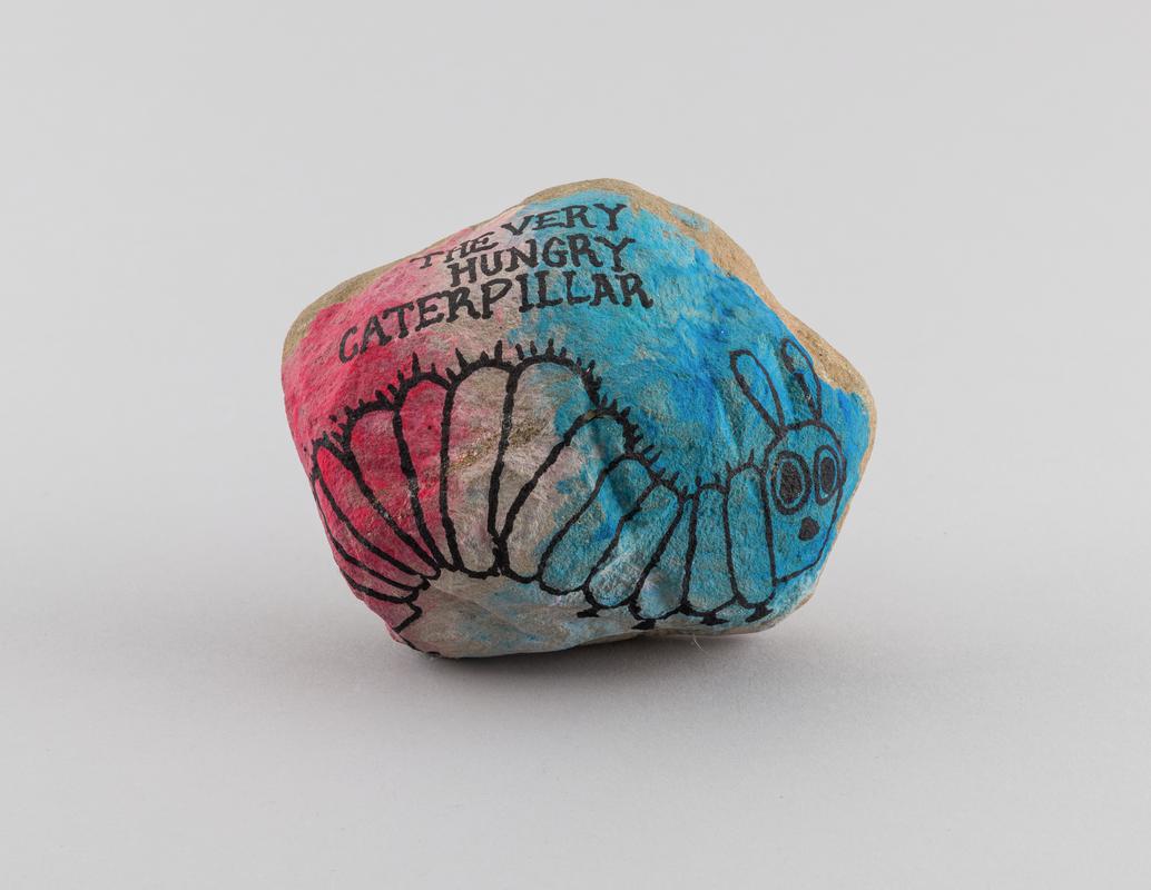 Stone painted with image of a caterpillar with inscription 'THE VERY / HUNGRY / CATERPILLAR' on the front