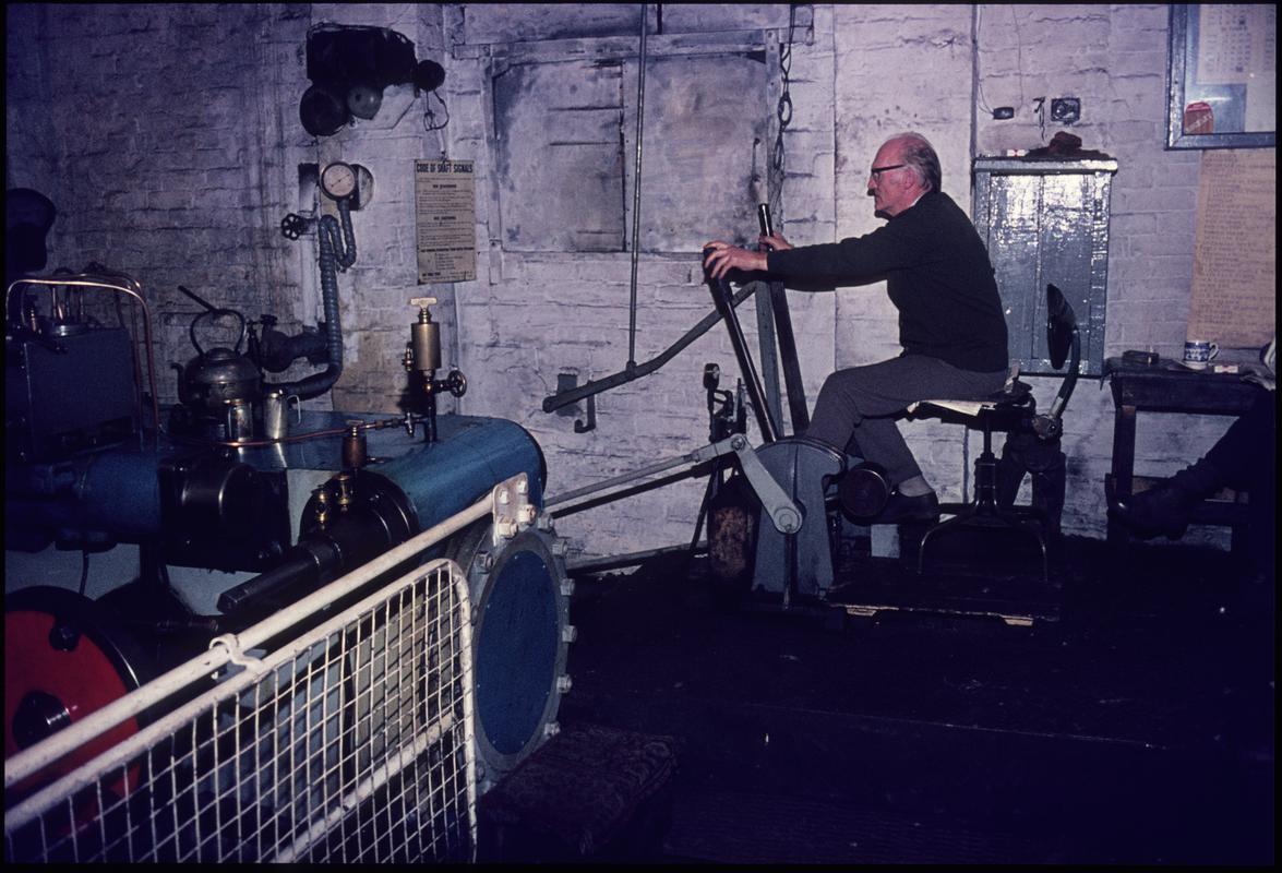 Colour film slide showing a man operating the Andrew Barclay winding engine, Morlais Colliery, c.1975.