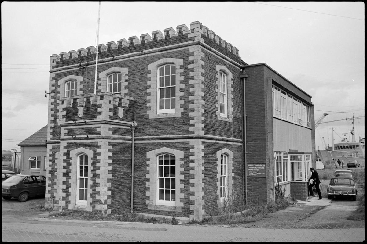 Exterior view of the Customs and Excise building with an officer entering the building, Roath basin, Cardiff Docks.