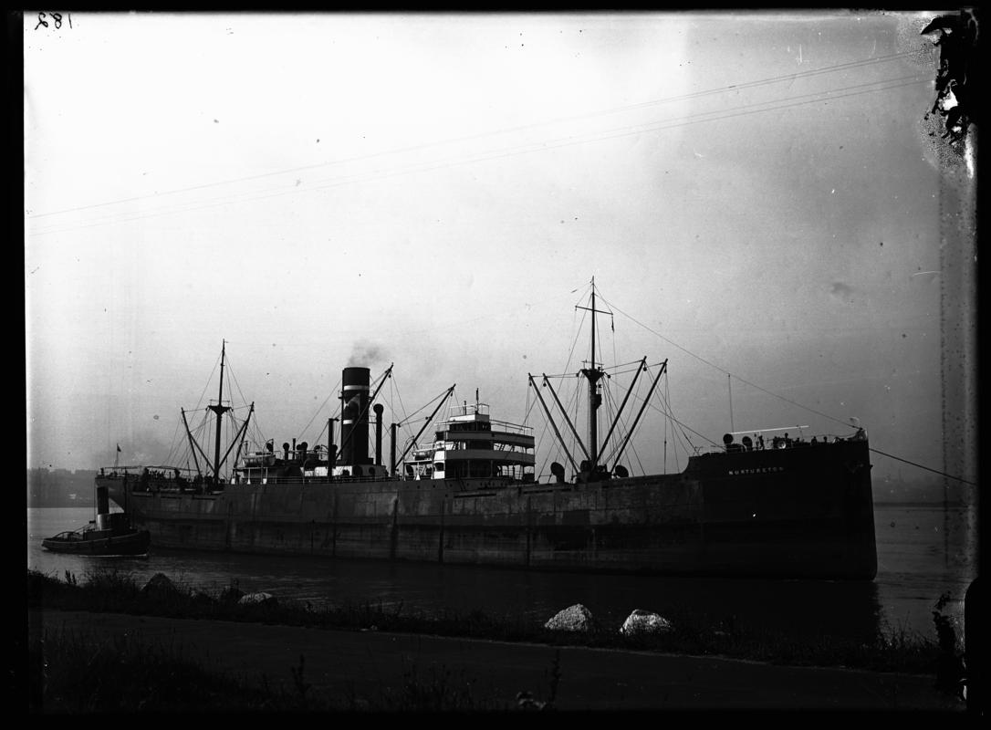 Starboard broadside view of S.S. NURTURETON and tug, c.1936.