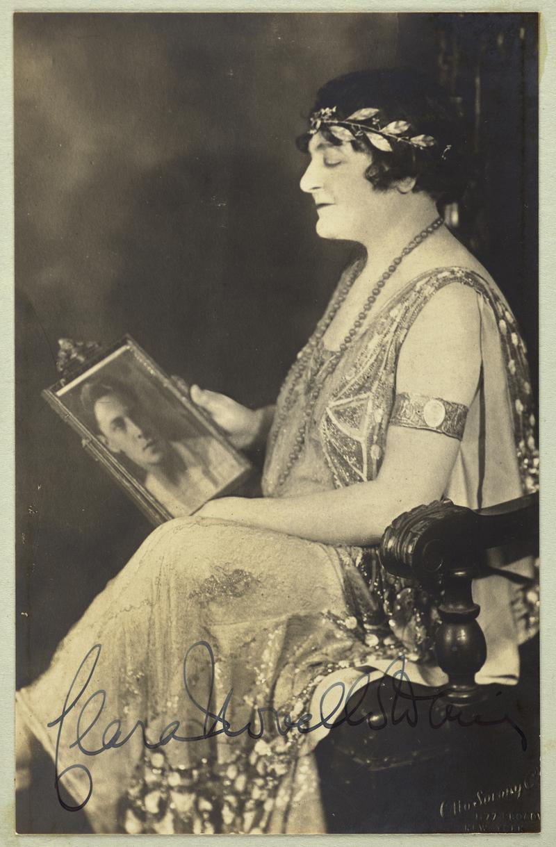 Studio photograph of Madame Clara Novello Davies seated holding a photograph of her son Ivor Novello.