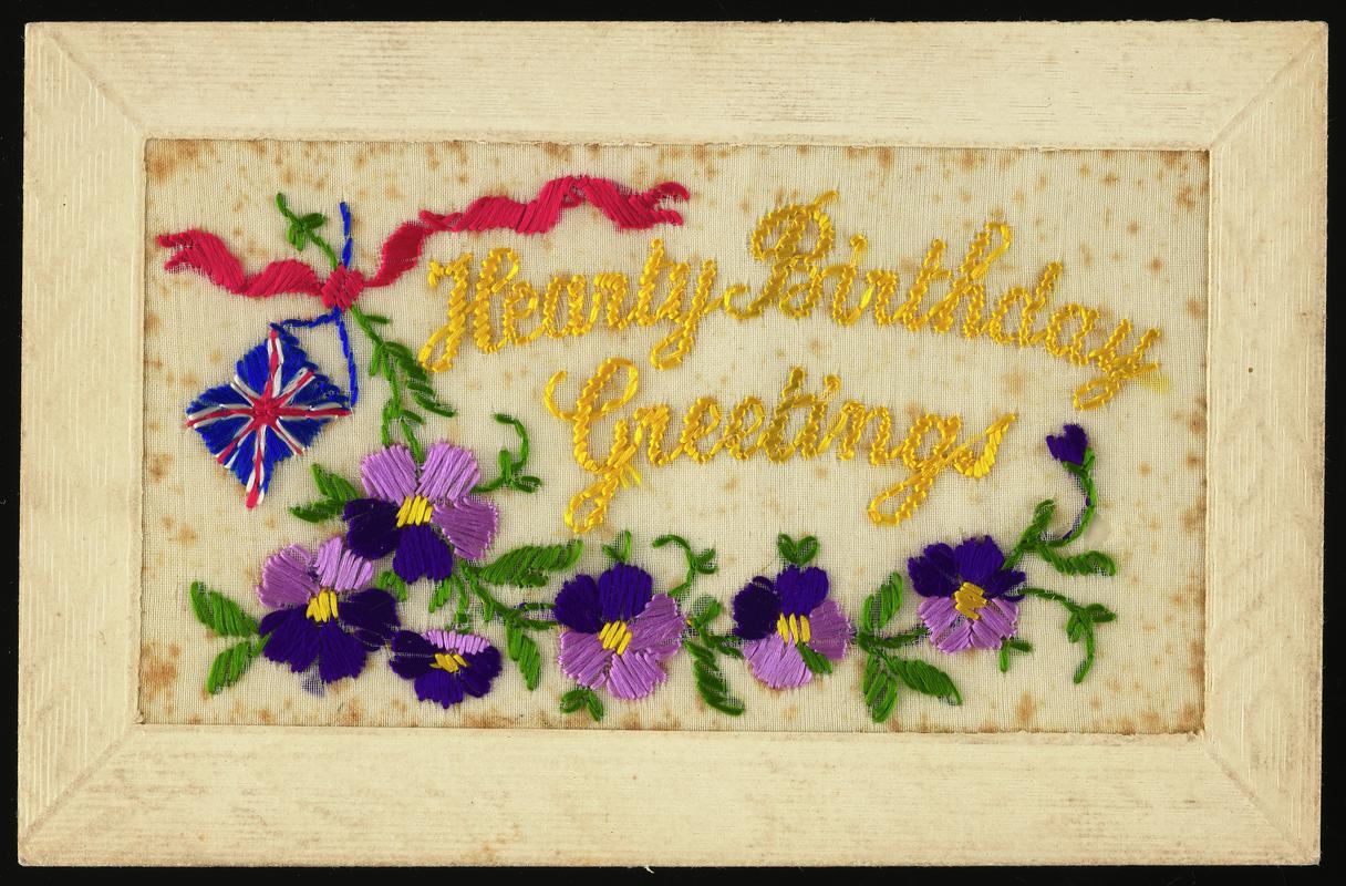 Embroidered postcard inscribed 'Hearty Birthday Greetings'. Handwritten message on back. Sent to Miss Evelyn Hussey, sister of Corporal Hector Hussey of the Royal Welch Fusiliers, during the First World War.