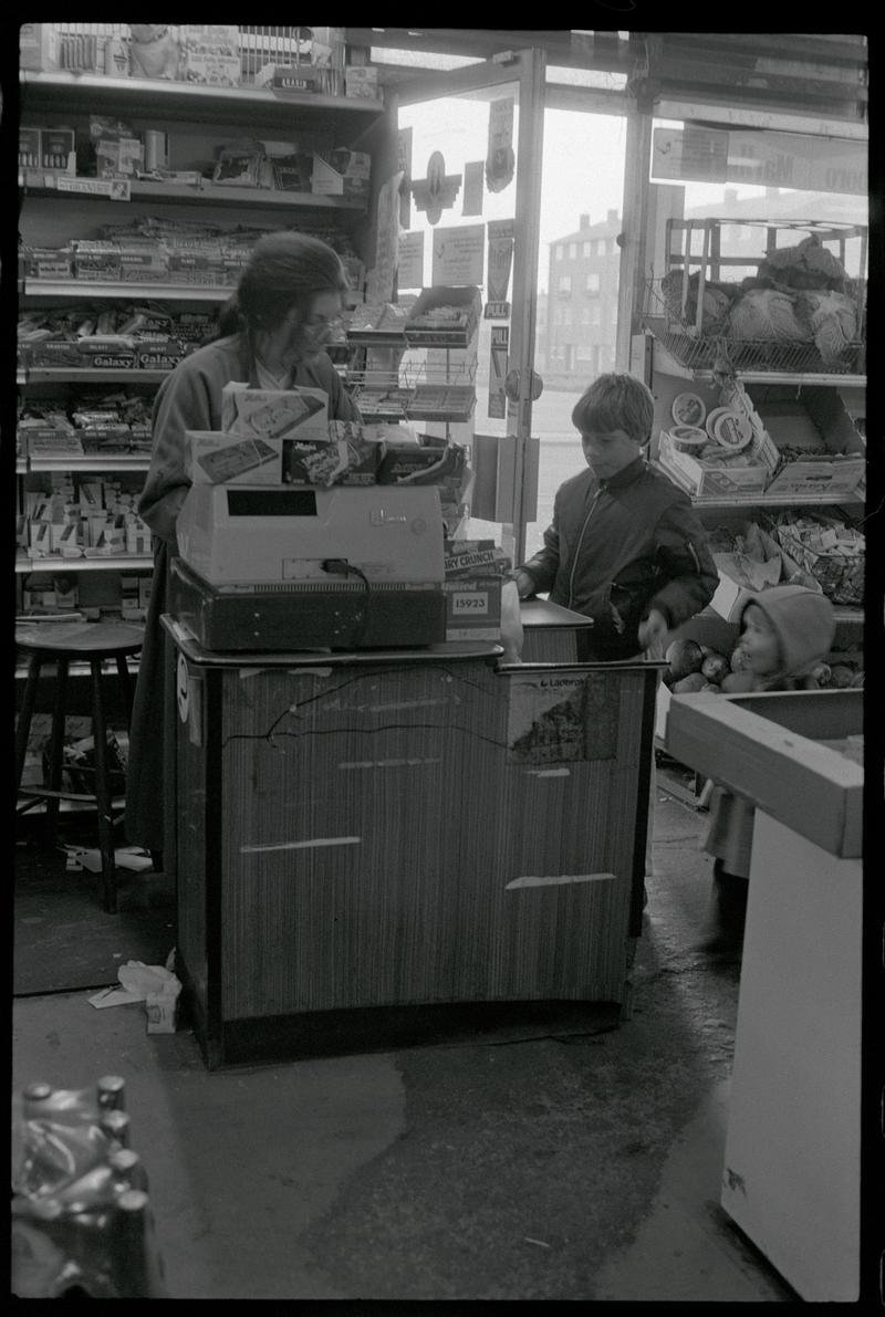 Cashier and customer in supermarket, Loudoun Square, Butetown.