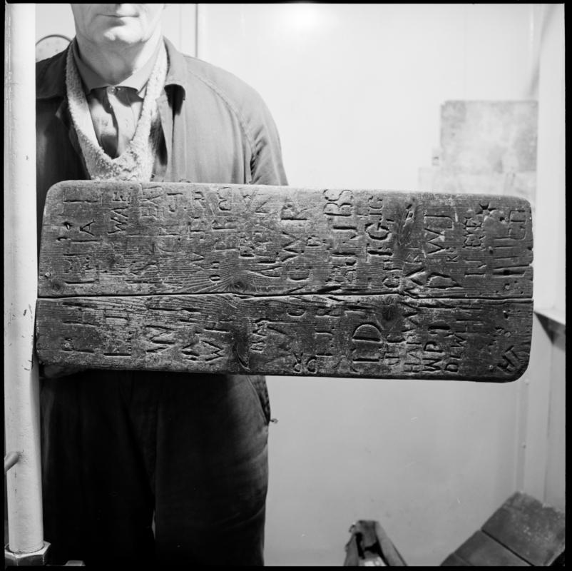 Black and white film negative showing a carved back rest, Big Pit, carved with initials (possibly of winding engine drivers).  'Back Rest Big Pit' is transcribed from original negative bag.