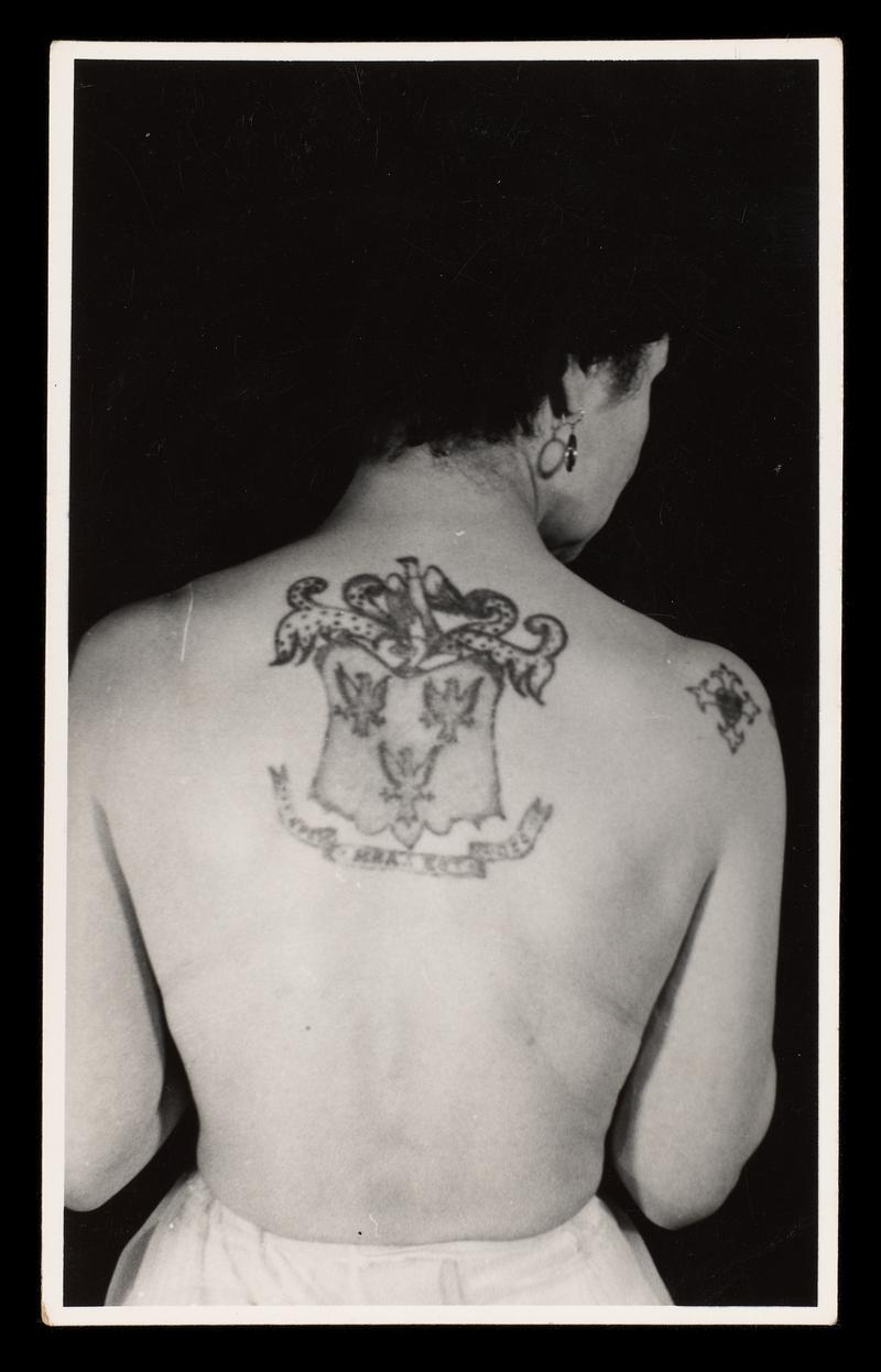 Black and white photograph: half figure of female with crest of Jessie Knight on her back (female is probably JK).