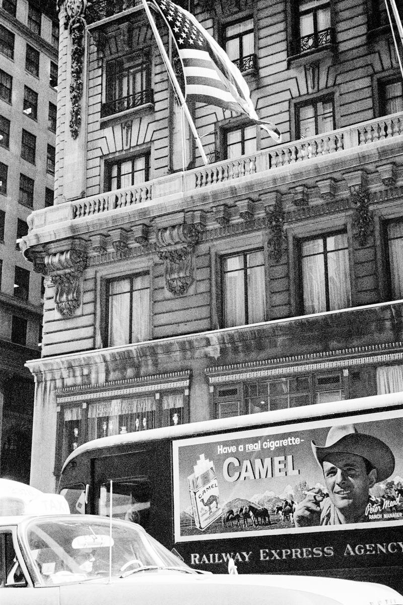 USA. NEW YORK. Lower Manhattan. Camel poster plus the American Flag. 1962.