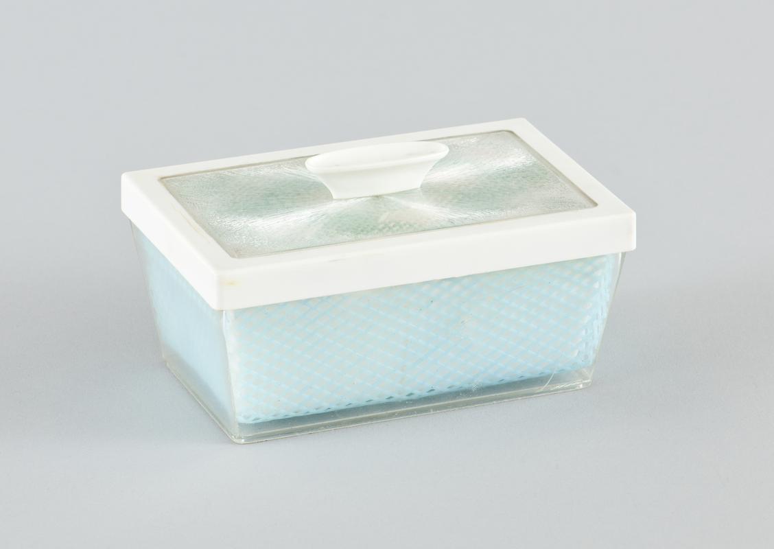 Plastic butter dish with removable lid. base of dish comprises white plastic reovable butter tray, blue plastic 'trellis' decorative sheet and these sit within clear plastic outer base. Top has blue and white checked material seen through clear plastic outer casing.
