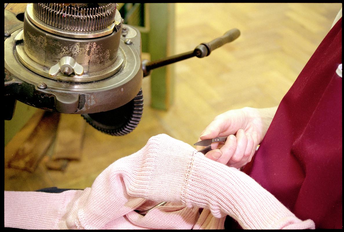 Andrea Rockman cutting yarn linking two cashmere socks. Corgi Hosiery Ltd factory, Ammanford, 1 July 2002.