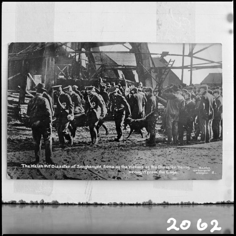 Black and white film negative of a photograph showing the scene at Universal Colliery, Senghenydd after the explosion of 14 October 1913.  Caption on photograph reads 'the Welsh Pit disaster at Senghenydd. Some of the victims of the disaster being brought from the cage'.  'Senghenydd' is transcribed from original negative bag.  Appears to be identical to 2009.3/1571.