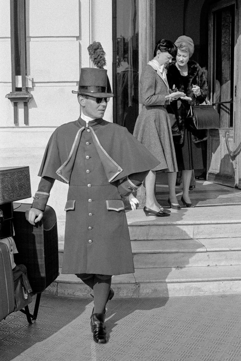 FRANCE. Nice. Concierge and guests outside the main entrance of the Hotel Negresco on the sea front promenade in Nice. 1964.