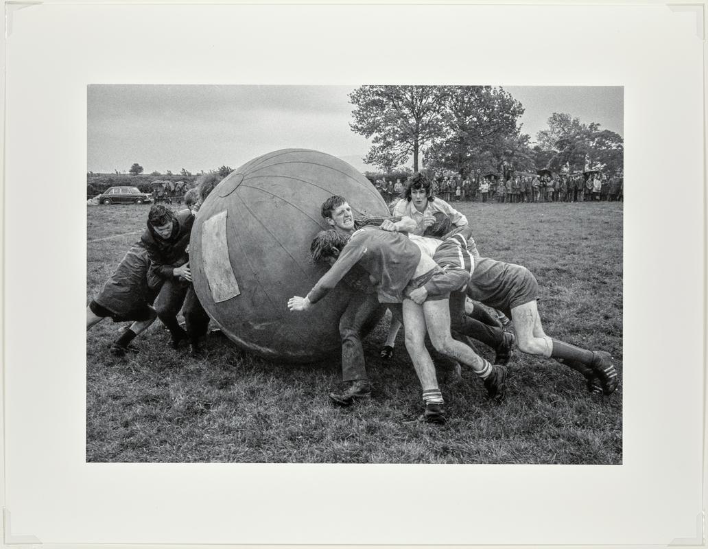 A game of push ball. Two teams try to push a large inflated ball over the opposition's goal line. Taking place at the Young Farmers' meeting. Brecon, Wales