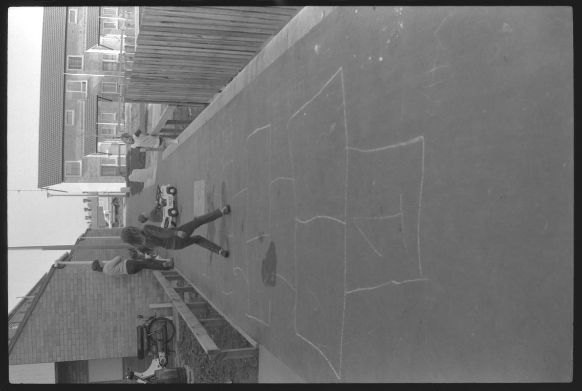 Child playing hopscotch at Eleanor Place, Butetown.