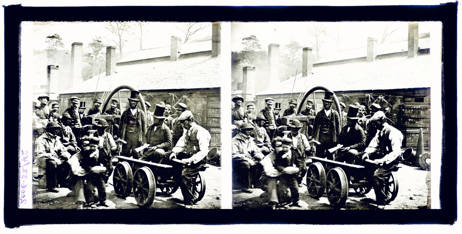 Glass stereoscopic slide showing managers and workmen grouped around a rail bogie and a flywheel, outside workshops, Brymbo.