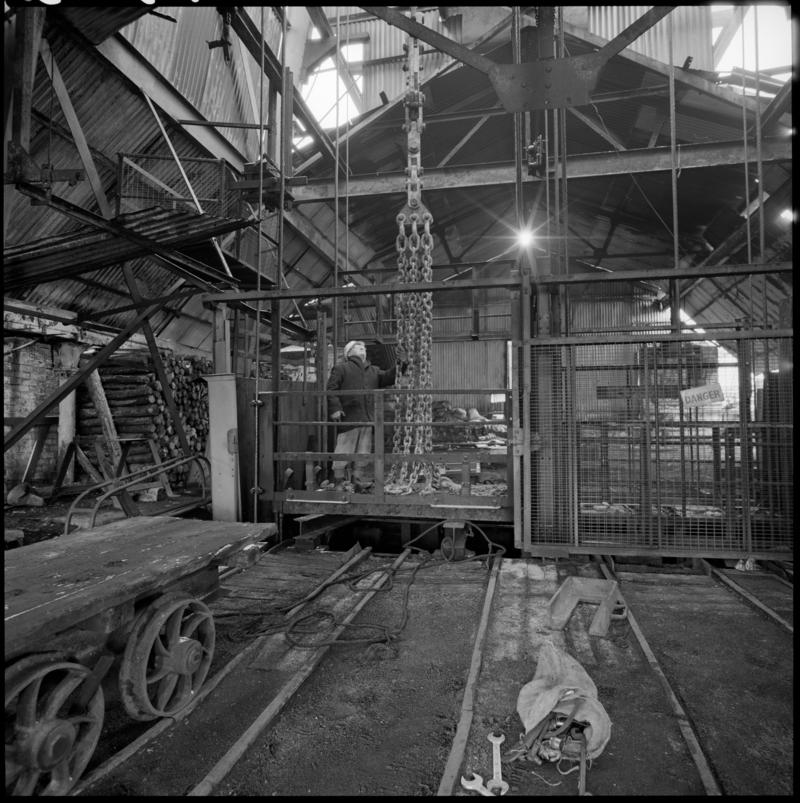 Black and white film negative showing man standing on top of cage at pit top, Big Pit Colliery January 1982.  'Big Pit Blaenavon Jan 1982' is transcribed from original negative bag.