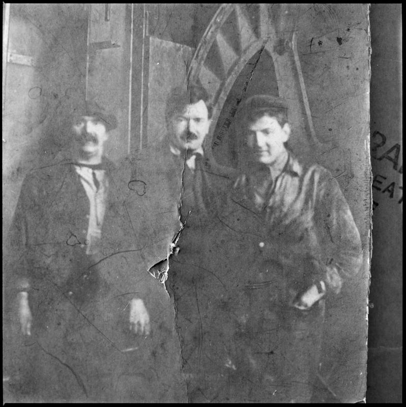 Black and white film negative showing a photograph of three men stood in front of a ?waddle fan, Deep Navigation Colliery.  'Deep Navigation' is transcribed from original negative bag.  Appears to be identical to 2009.3/1237.