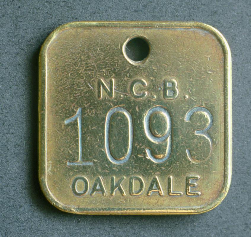 Colour film slide showing an Oakdale Colliery lampcheck engraved 'N.C.B. 1093 OAKDALE'.