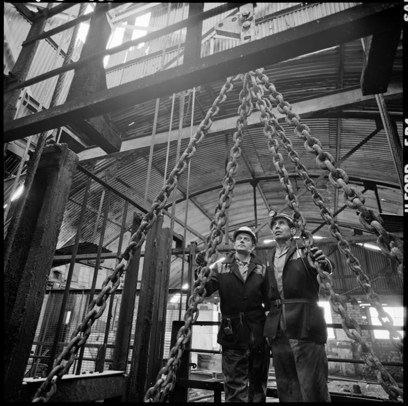 Black and white film negative showing men standing on top of cage at pit top, Big Pit Colliery January 1982.  'Big Pit Blaenavon Jan 1982' is transcribed from original negative bag.