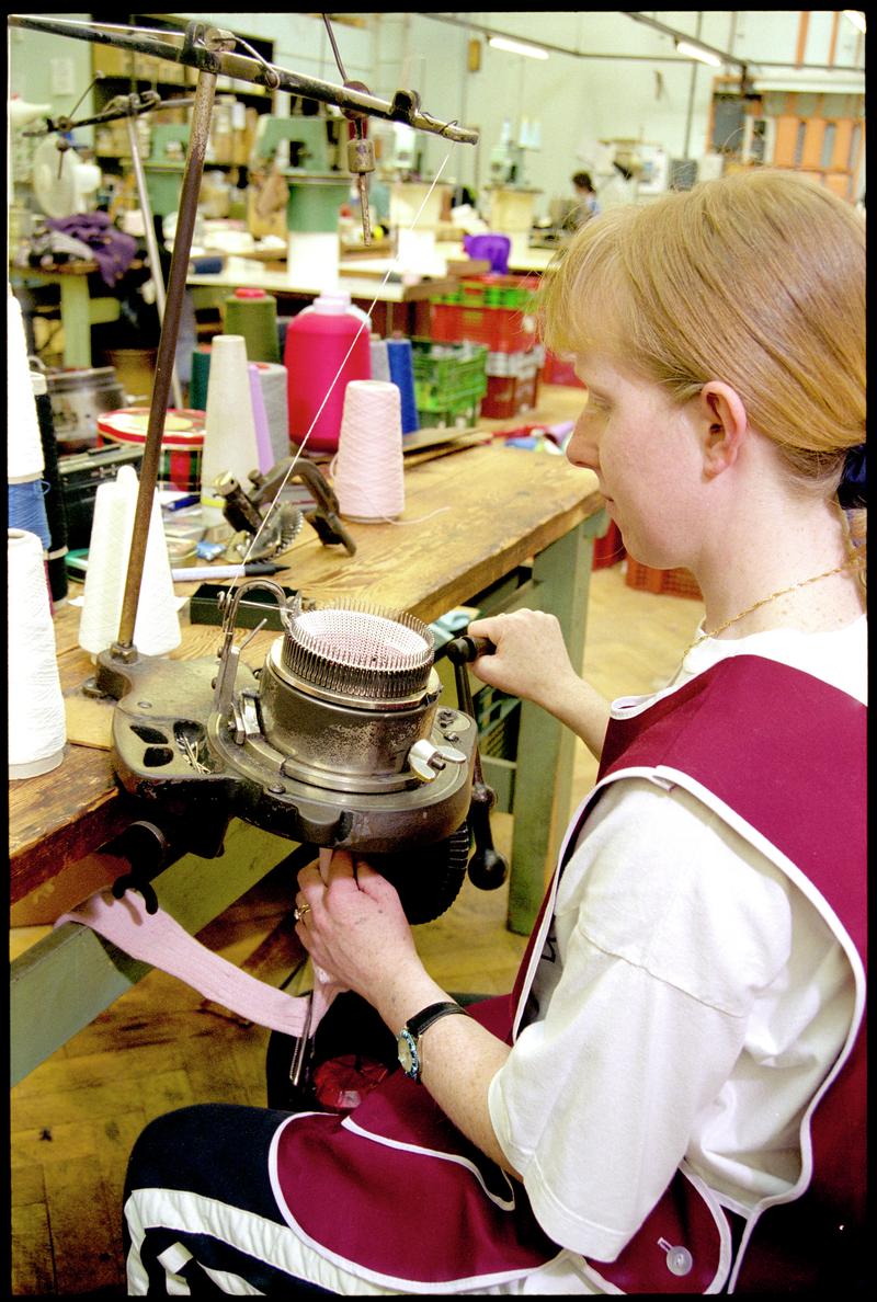 Andrea Rockman operating a hand turned sock knitting machine. Corgi Hosiery Ltd factory, Ammanford, 1 July 2002.