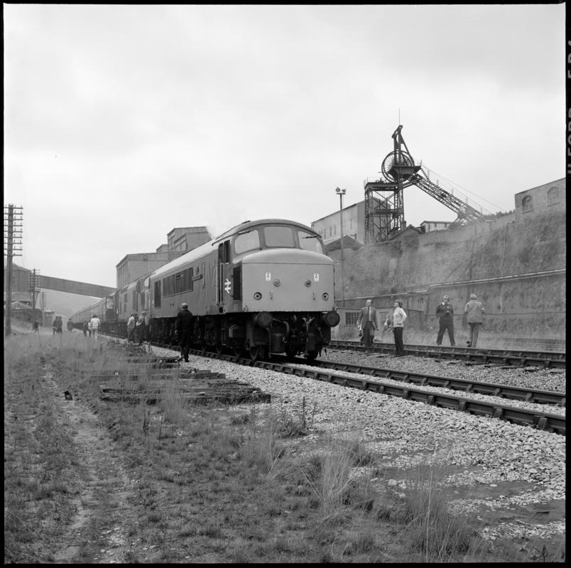 Black and white film negative showing a locomotive passing through Abertillery New Mine, 1977. '1977' is transcribed from original negative bag.