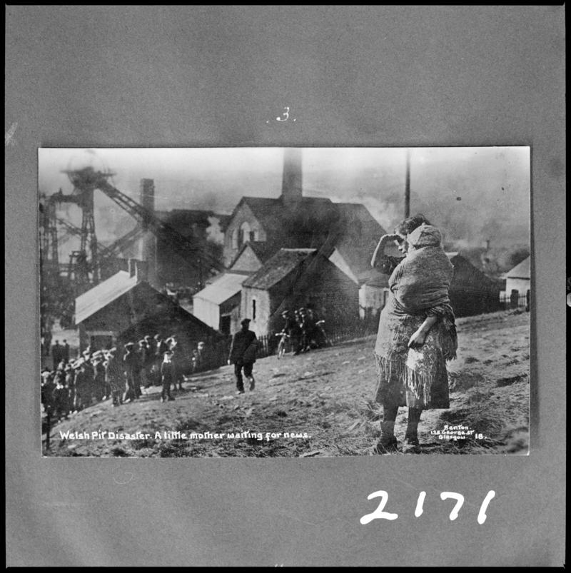 Black and white film negative of a photograph showing the scene at Universal Colliery, Senghenydd following the disaster of 14 October 1913. Caption on photograph reads 'Welsh pit disaster.  A little mother waitingfor news'.  'Sen 1913' is transcribed from original negative bag.