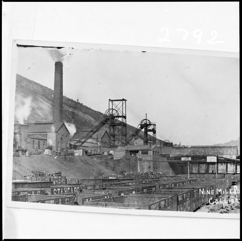 Black and white film negative of a photograph showing a surface view of Nine Mile Point Colliery, Cwmfelinfach. 'Nine Mile Point' is transcribed from original negative bag.
