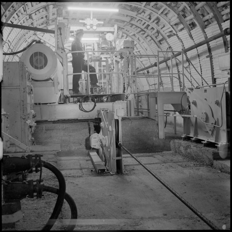 Black and white film negative showing a man operating a haulage engine underground at Cwmtillery Colliery.  'Cwmtillery' is transcribed from original negative bag.