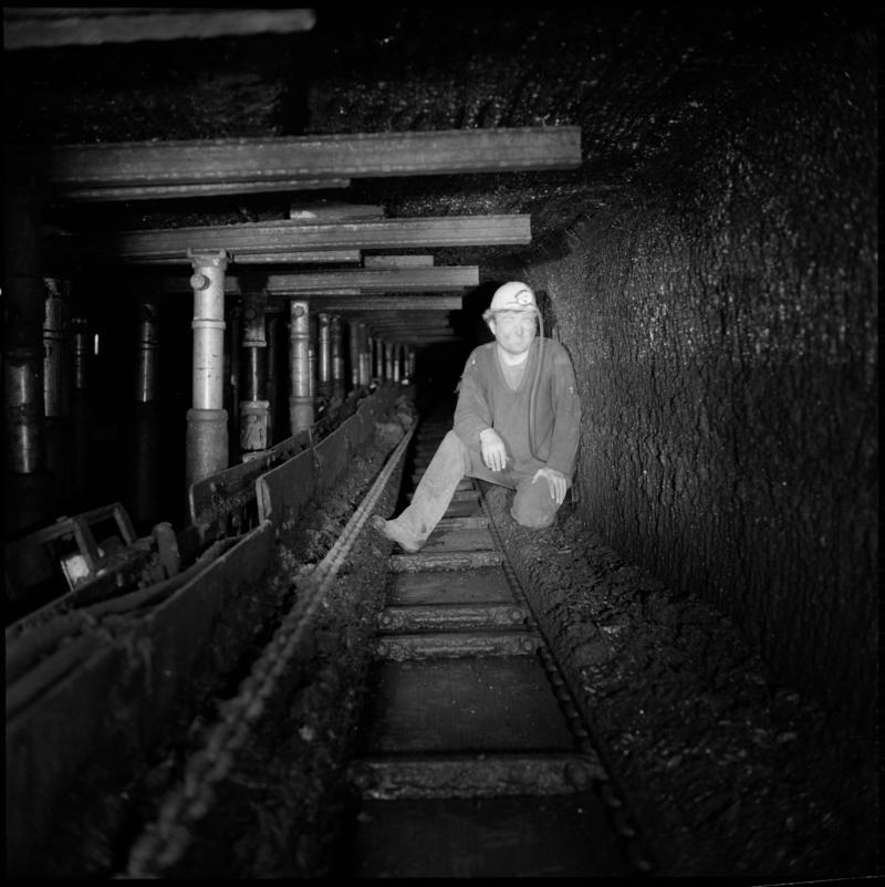 Black and white film negative of a photograph showing a man beside props and bars underground at Celynen South, Colliery 19 July 1976.  'South Celynen 19/7/1976' is transcribed from original negative bag.
