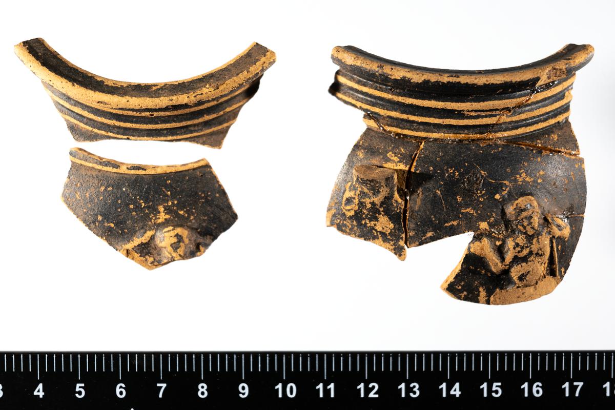 Bowl sherds showing a figure - satyr or silenus. Described as 'black samian'.