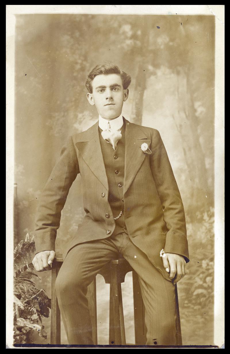 Gentleman dressed in a smart suit sitting on a stool (front & Back)