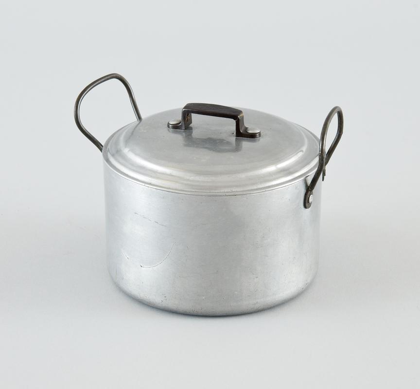 Aluminium saucepan with lid, with metal handles on either side. Plastic handle on lid. Deep scratches on one side.