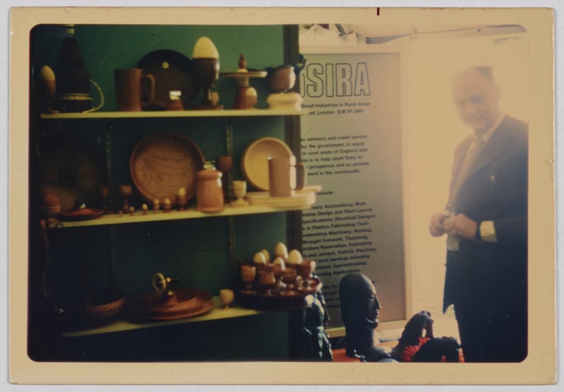 Newton Edwards, woodturner and carver, at a display stand of his work, National Eisteddfod in Ruthin, 1973. - Photographic Print