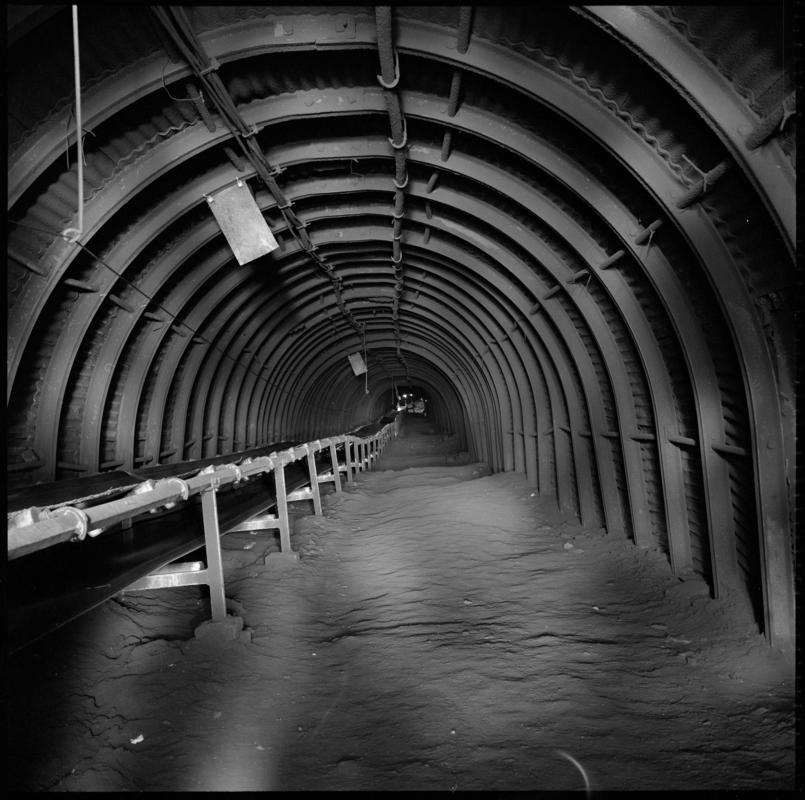 Black and white film negative showing a roadway and conveyor belt, Cwmgwili Colliery.  'Cwmgwili' is transcribed from original negative bag.