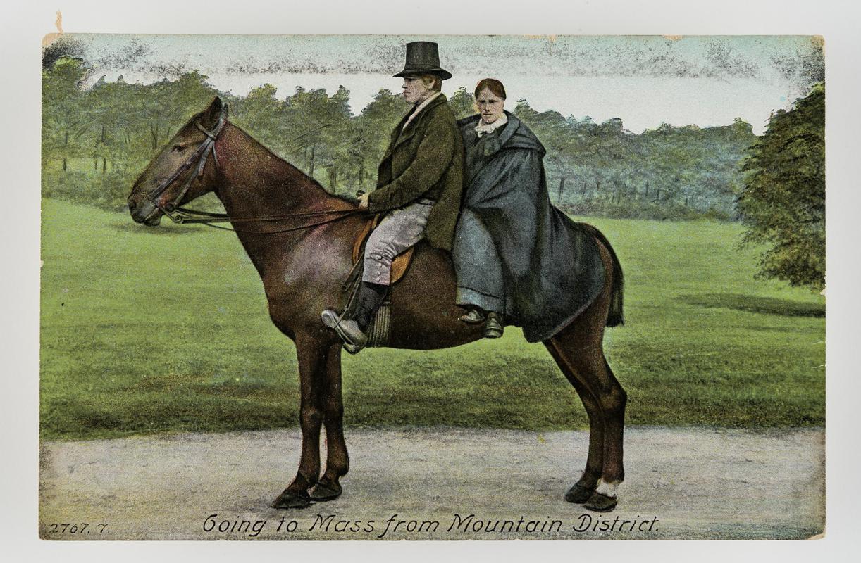 Tinted postcard of man & woman sitting on a horse, entitled 'Going to Mass from mountain district'.