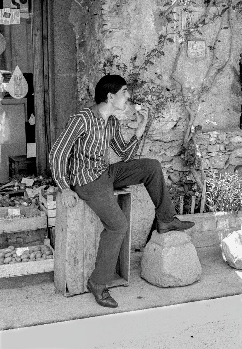 ITALY. Sicily. Taormina. Fruit seller tasting his produce. 1964.