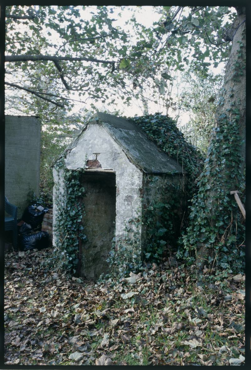 Graffitied tŷ bach in a garden in Trefin, slide