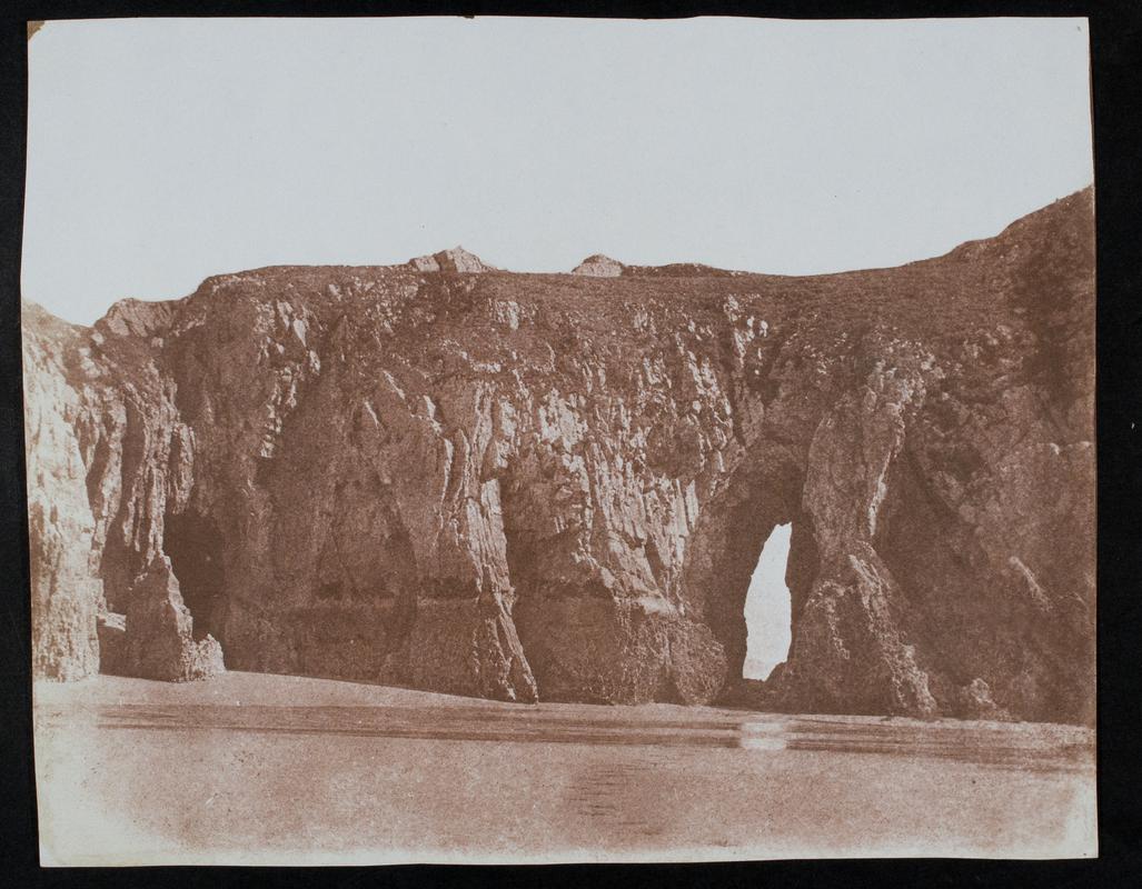 Rock arch in cliff (Three Cliffs Bay?), photograph