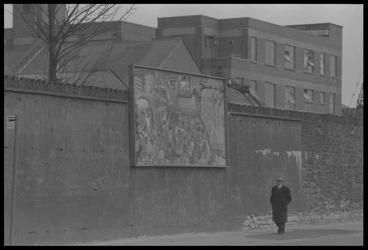 Mural on wall of railway embankment.