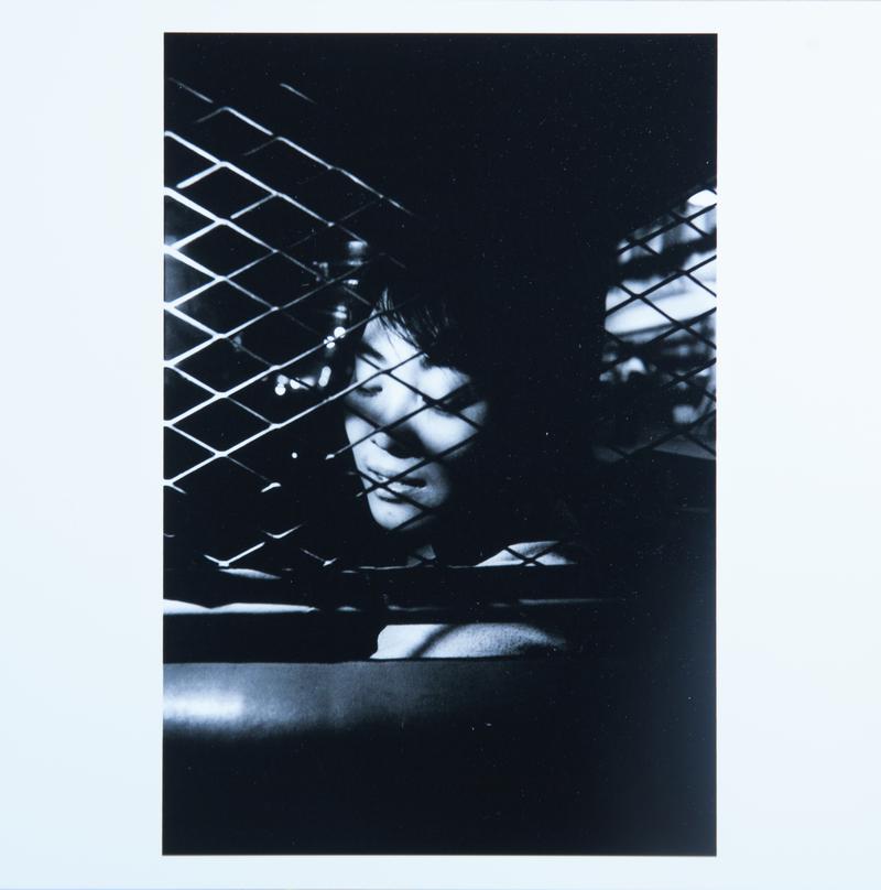 Young woman in the front seat of a taxi, separated by a wire net as protection for the driver against aggressions