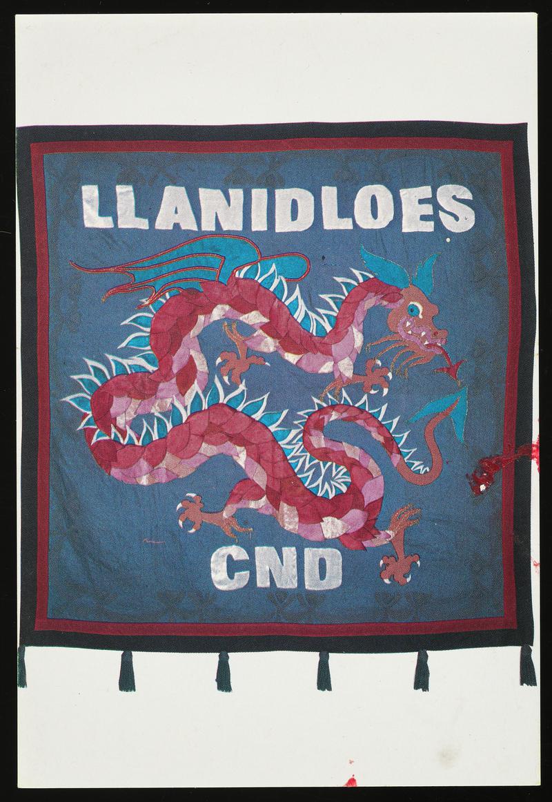 Colour postcard of a Llanidloes CND banner. Original banner Designed by Gini Wade & Ron Simpson and made by The Llanidloes CND group. The dragon, the heraldic animal of Wales, is a well-known symbol of positive energy.