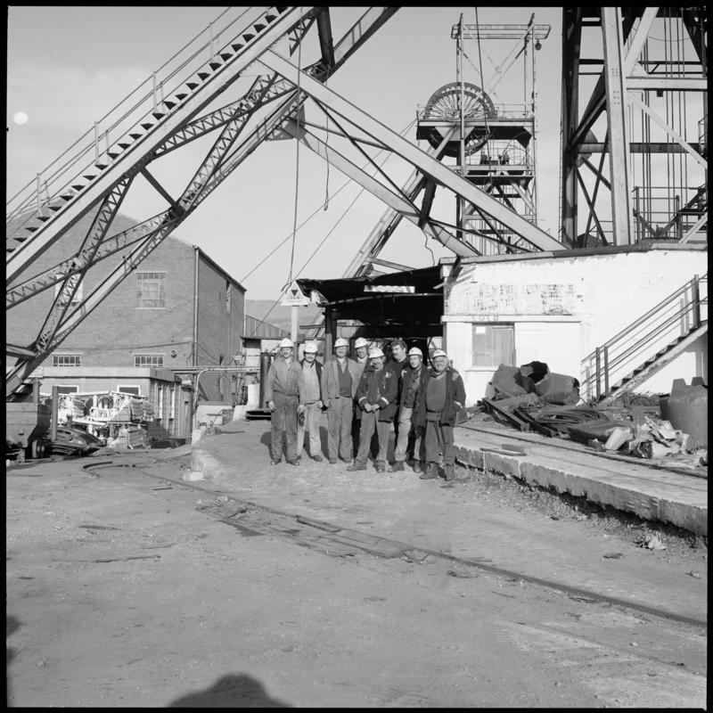Black and white film negative showing a group of miners and both headframes, Western Colliery . 'Western' is transcribed from original negative bag.