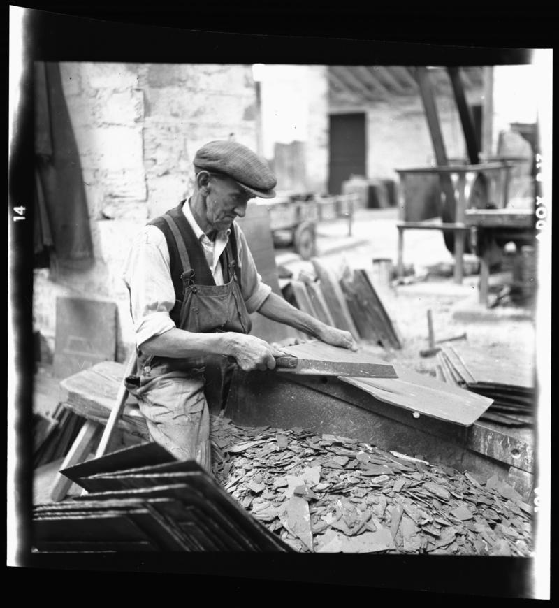 Quarryman dressing a roofing slate using a slate trimming knife, 'cyllell naddu', Dinorwig Quarry, early 1960s.