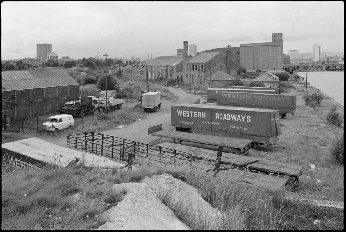 View of the old buildings on the west side of Bute East Dock. Parked in the foreground are large trailers used by Western Roadways.