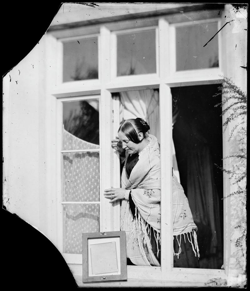 Emma making a photographic print, glass negative