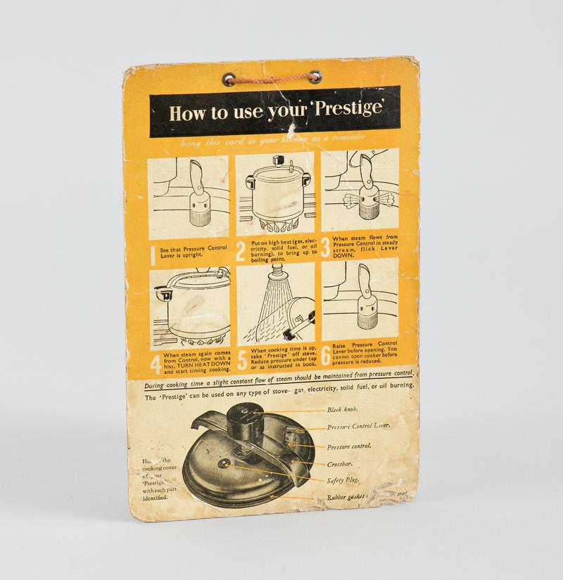 Instruction card 'How to Use your Prestige' with orange cord tied through eyelets at top for hanging up.